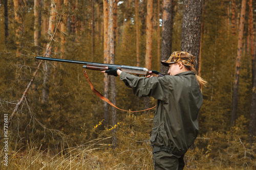 Woman hunter in the woods. Autumn hunting season. Hunting Conceptual background. Outdoor sports.
