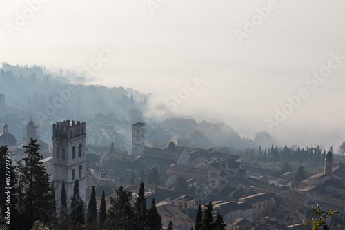 Beautiful view of Assisi (Italy) with fog below and on the background, and bell tower on the foreground