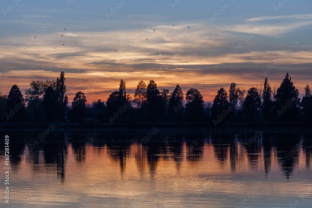 Field, river and beautiful sky and clouds reflected