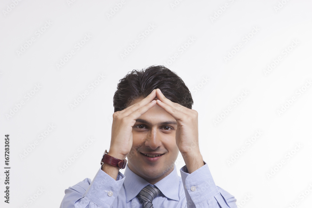 Businessman making house sign Businessman making house sign