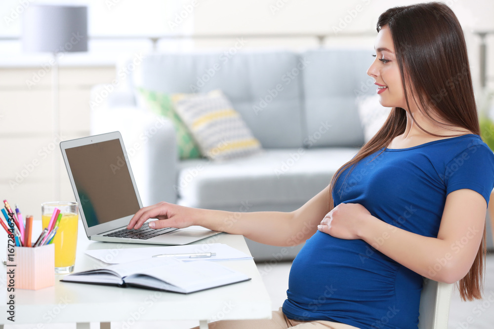 Beautiful young pregnant woman working at home Beautiful young pregnant woman working at home