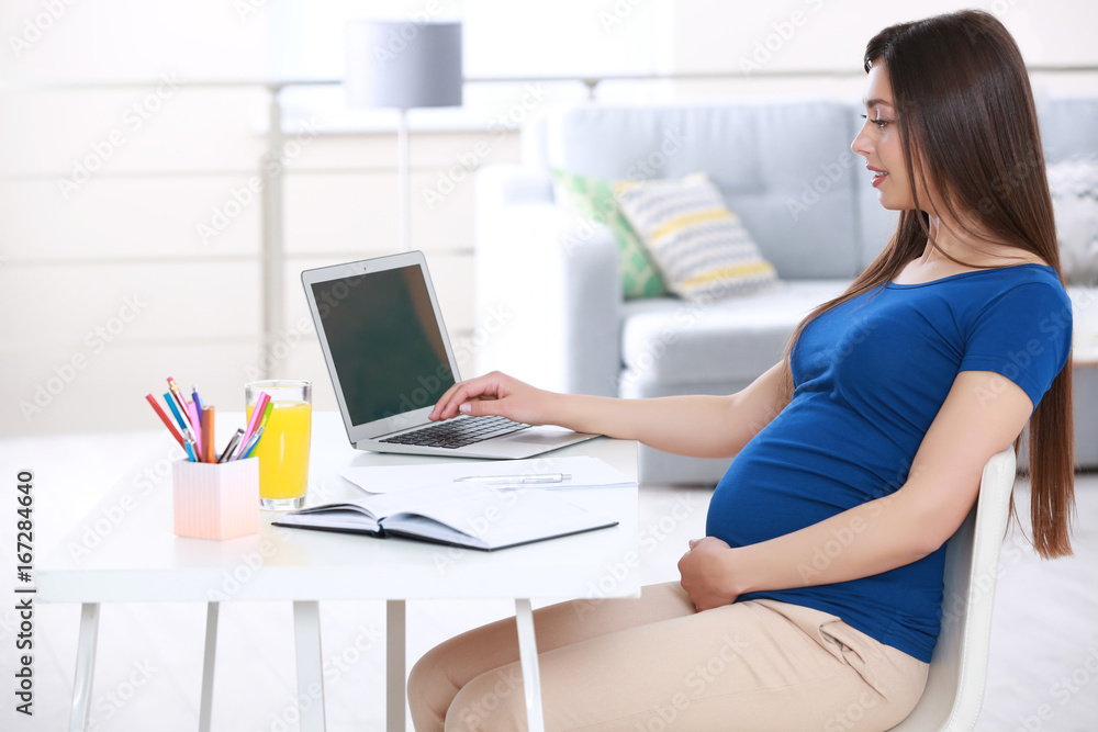 Beautiful young pregnant woman working at home Beautiful young pregnant woman working at home