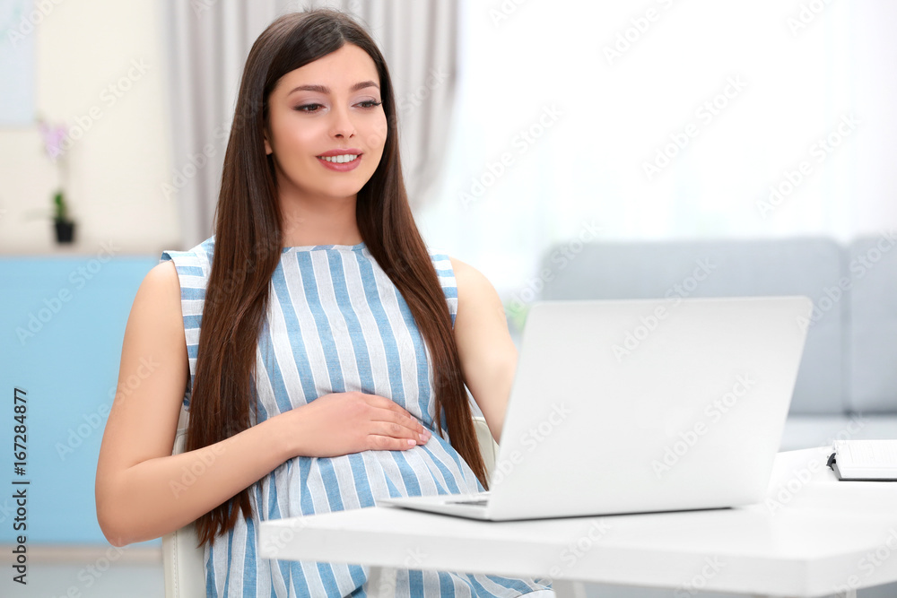 Beautiful young pregnant woman working at home Beautiful young pregnant woman working at home