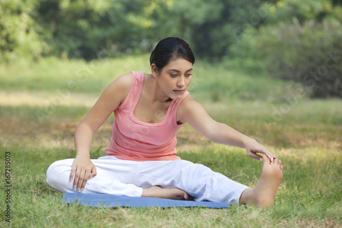 Woman on grass stretching 
