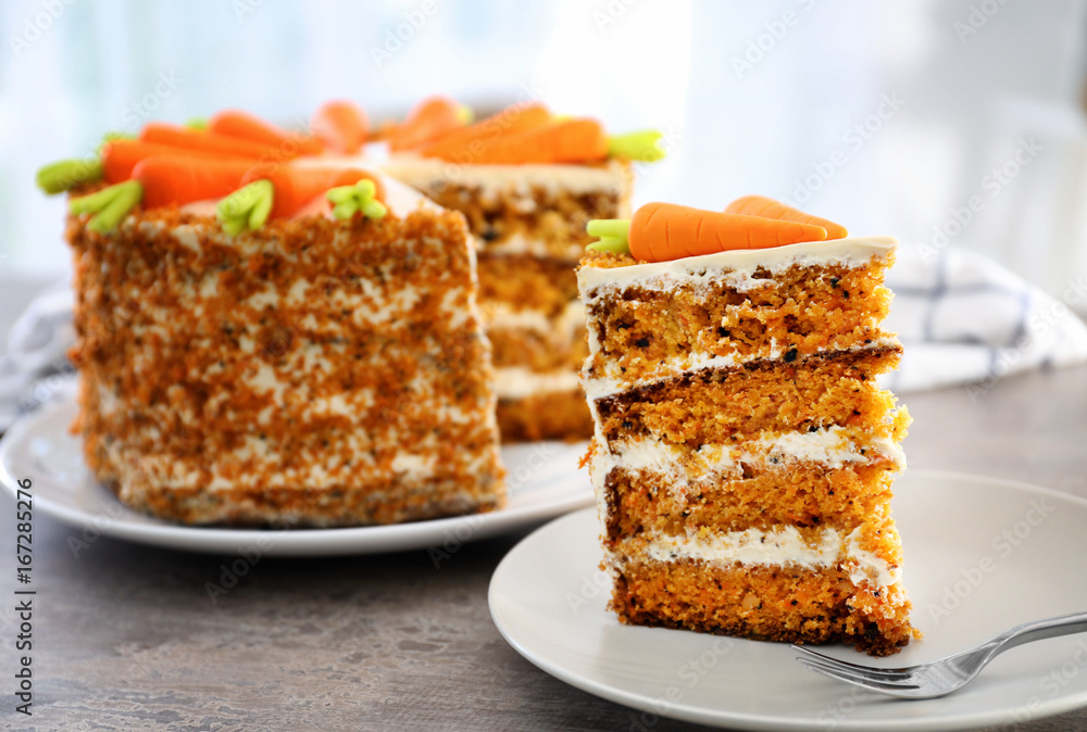 Delicious sliced carrot cake on table