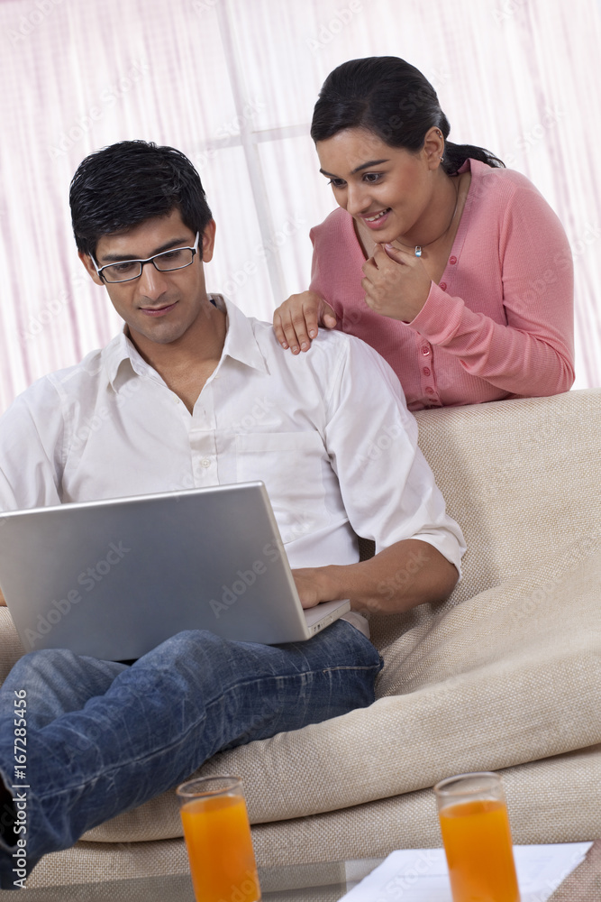 Young couple using laptop at home Young couple using laptop at home