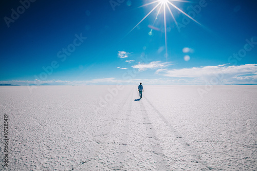 Boy walking in Uyuni salt flats photo