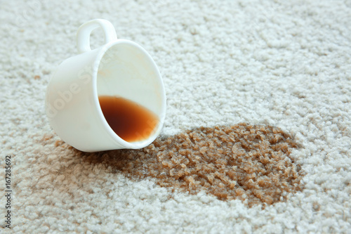 Obraz na plátně Cup of coffee spilled on white carpet, close up