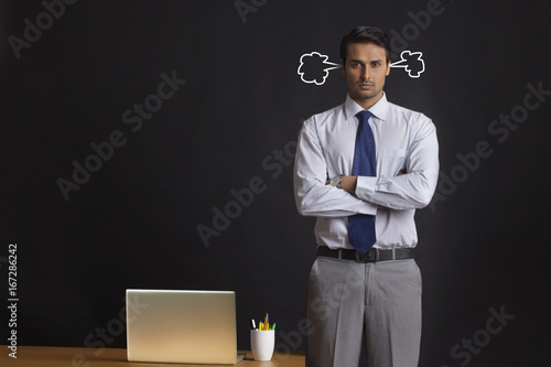 Digitally generated image of furious young businessman with steam coming from ears in office