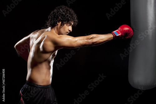 Young man hitting punching bag 