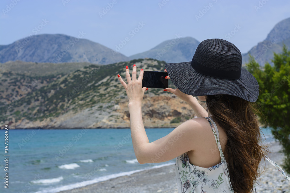 Fototapeta premium Woman traveler makes a self in the background beautiful natural view mountain on the island. Concept - tourism travel photos from vacation.