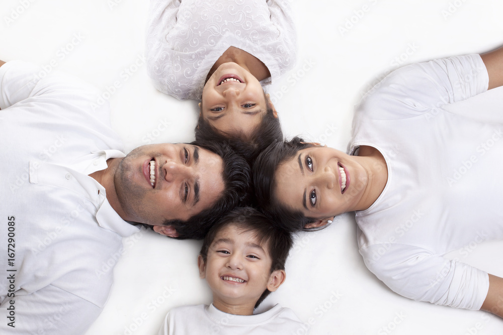 Family of four lying on white background 