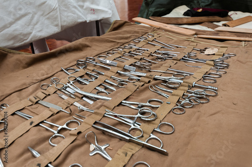 Large selection of stainless steel surgical equipment, including Magill and artery forceps, tweezers, retractors in canvas roll from WW1 photo