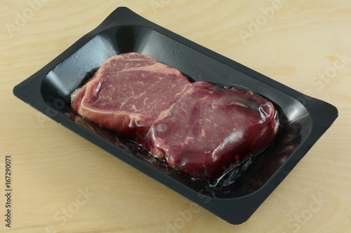 Raw New York Strip Steaks for two in plastic refrigerator packaging