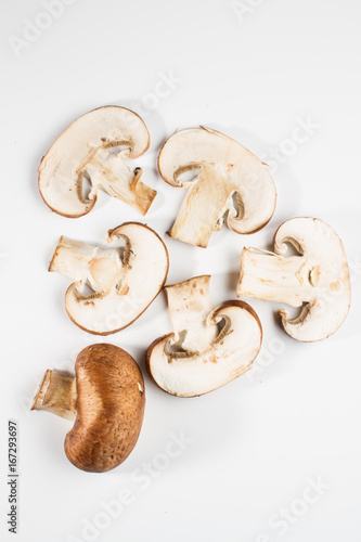 Mix of whole and sliced brown champignon mushrooms isolated on a white background