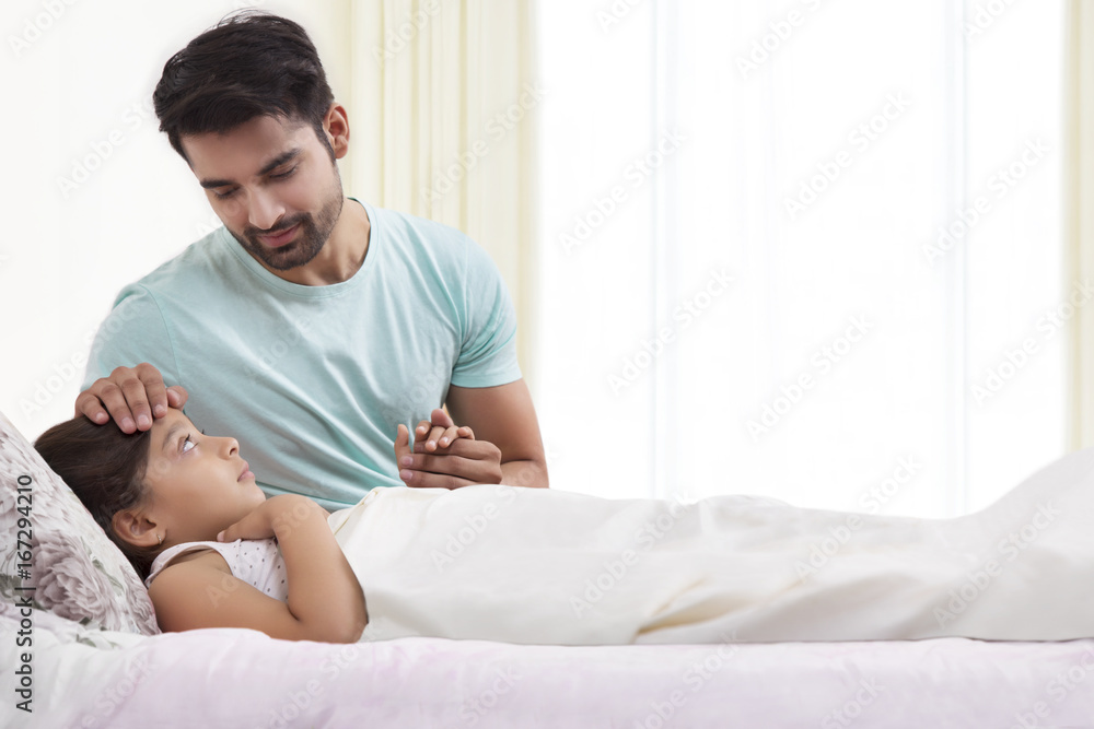 Father checking temperature of sick daughter Father checking temperature of sick daughter