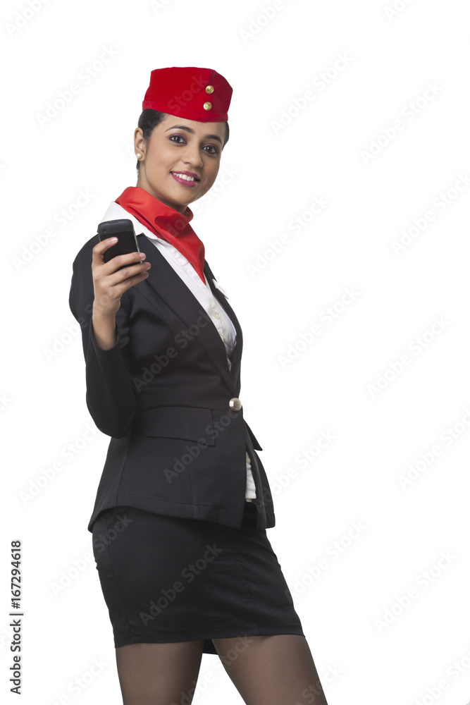 Portrait of happy young airhostess text messaging on cell phone isolated over white background Portrait of happy young airhostess text messaging on cell phone isolated over white background