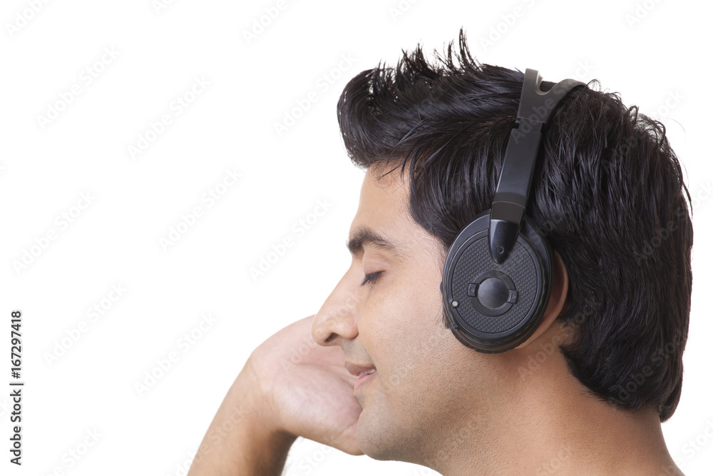 Naklejka premium Close-up of happy young man listening music 