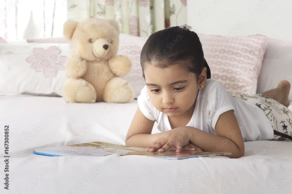 Girl reading book while lying in bed Girl reading book while lying in bed