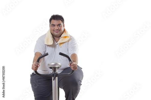Portrait of an obese man exercising over white background  © IndiaPix