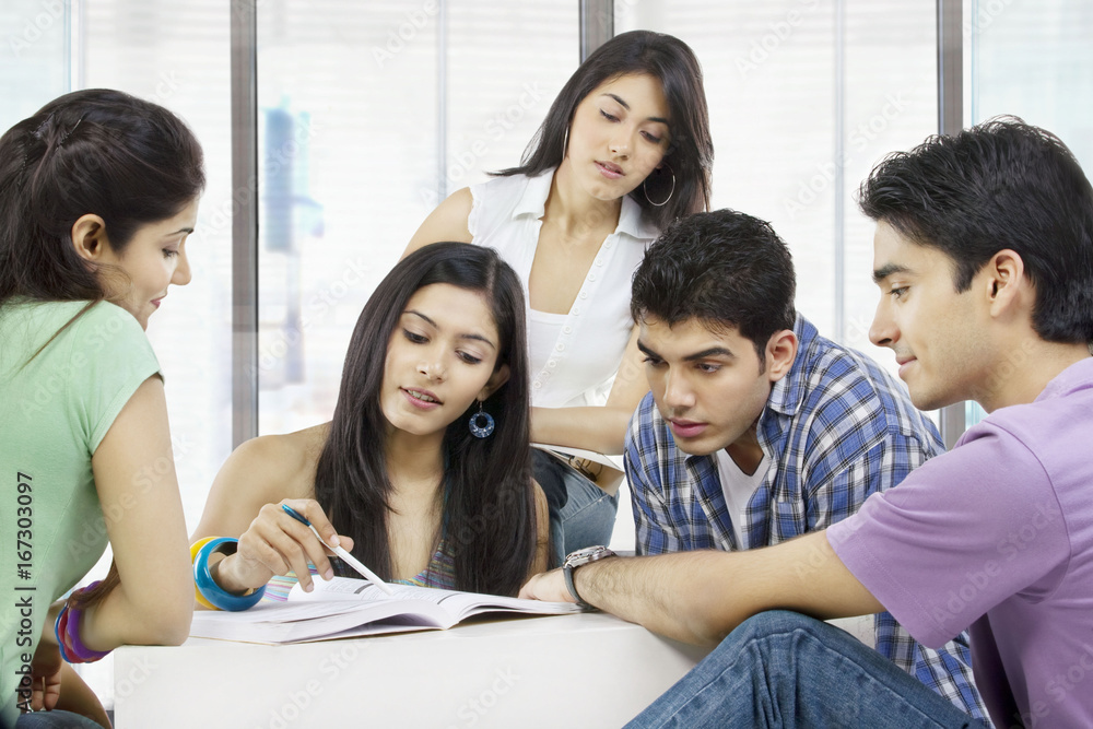 College students looking at a book College students looking at a book