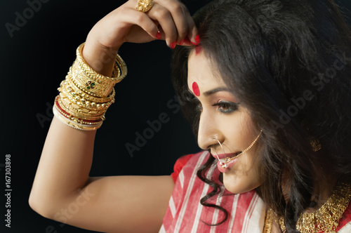 Bengali woman putting sindoor on her forehead  photo
