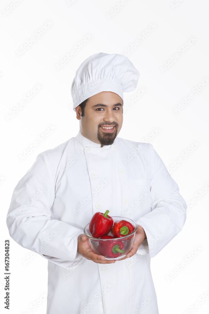 Portrait of chef with bowl of red capsicum Portrait of chef with bowl of red capsicum