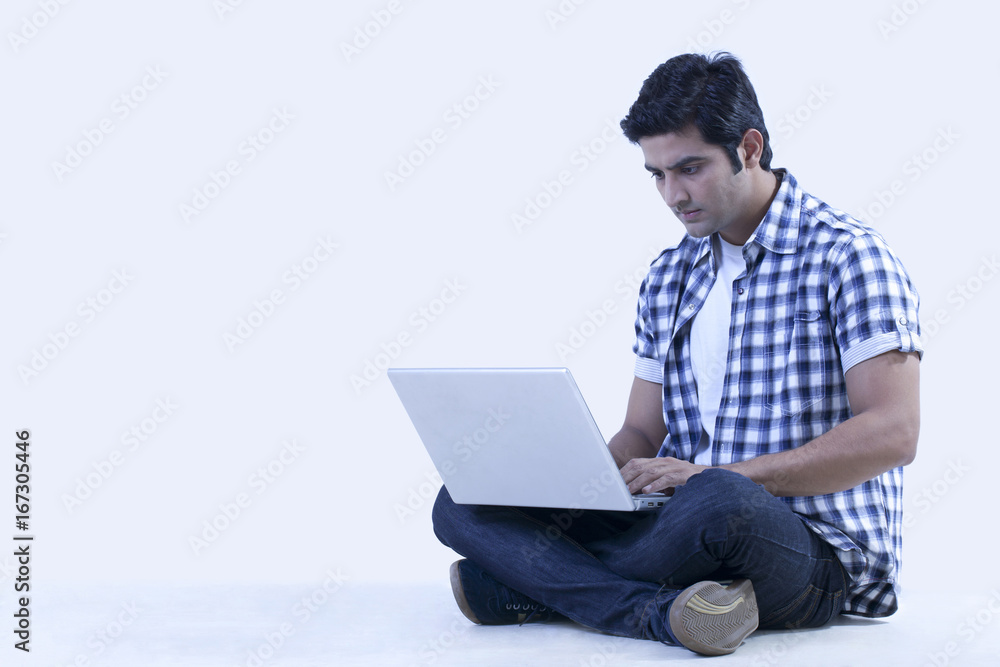 Serious university student using laptop Serious university student using laptop