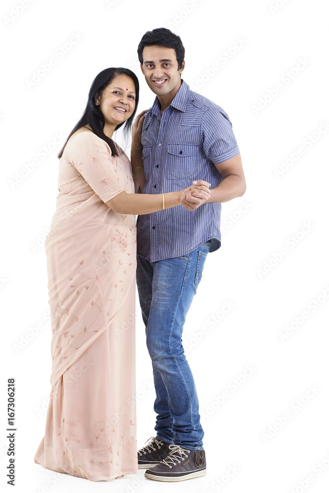Portrait of young man and mother dancing over white background Portrait of young man and mother dancing over white background