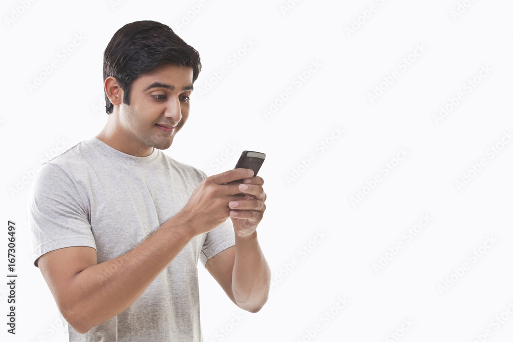 Young man reading text message and smiling Young man reading text message and smiling