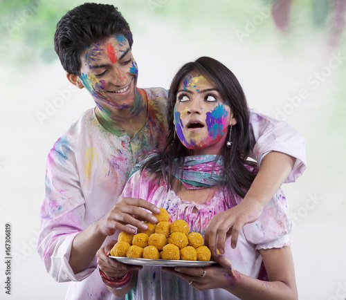 Man stealing a laddoo from a tray 