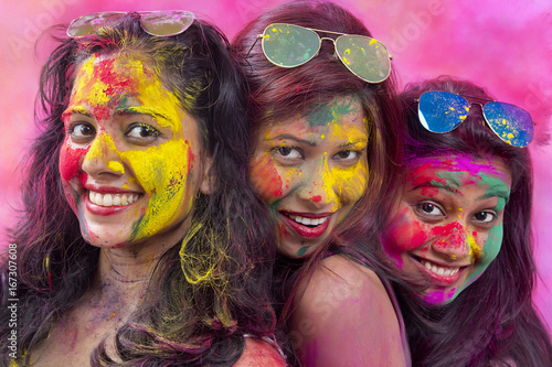 Portrait Of Three Young Indian Women With Colored Face celebrating Holi Color festival
