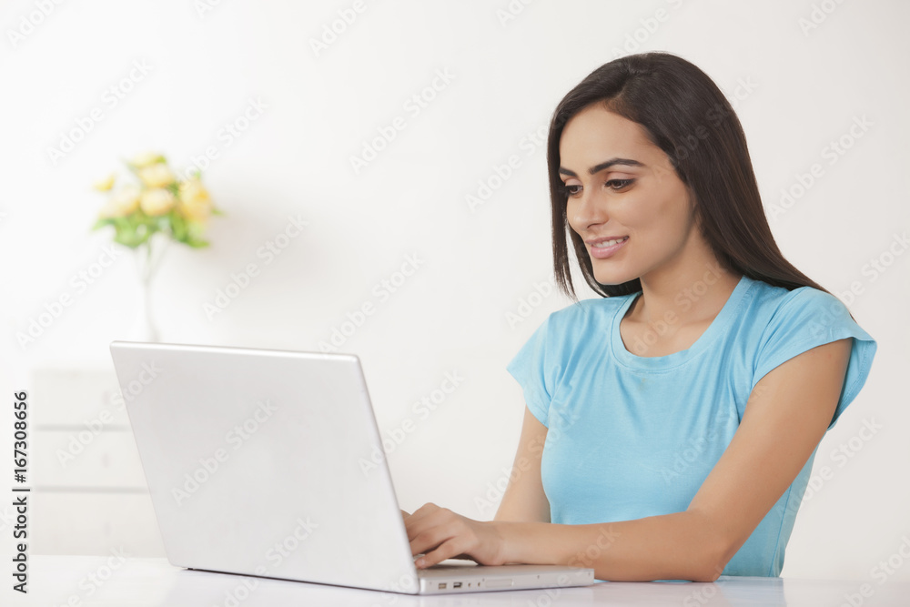 Beautiful young woman working on laptop at home Beautiful young woman working on laptop at home