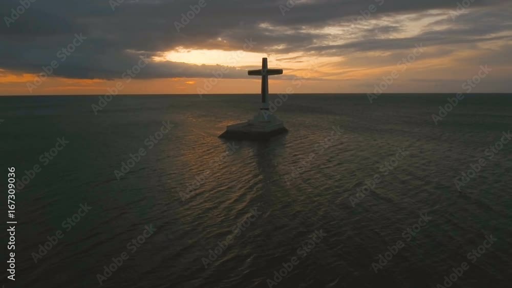 Aerial view Sunken Cemetery cross in Camiguin Island, Philippines,sunset. Large crucafix marking the underwater sunken cemetary of the coast of camiguin island near mindanao in the Philippines Aerial view Sunken Cemetery cross in Camiguin Island, Philippines,sunset. Large crucafix marking the underwater sunken cemetary of the coast of camiguin island near mindanao in the Philippines