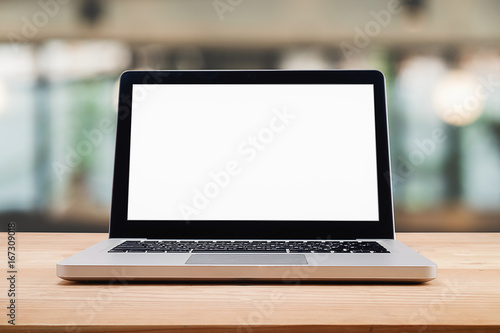 Computer with white screen on table with blur background. Technology concept.
