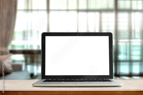 Laptop on table against bokeh lights living room background, blank screen for graphic display montage.