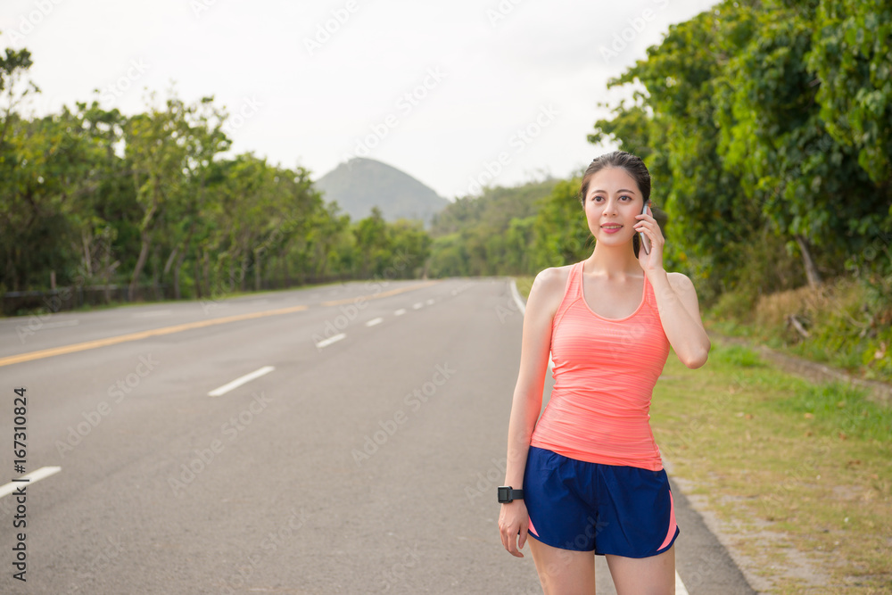 woman runner standing on road calling for family woman runner standing on road calling for family