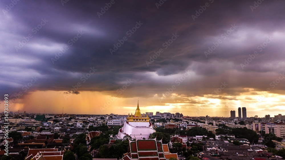  'Golden Mountain '  Wat Saket Ratcha Wora Maha Wihan popular Bangkok tourist attraction , Landmarks of bangkok Thailand . In the rain before , topview 