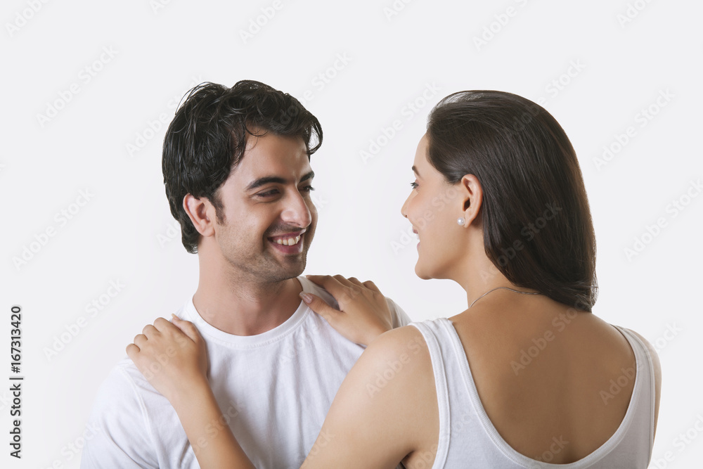 Happy young couple looking at each other over white background Happy young couple looking at each other over white background