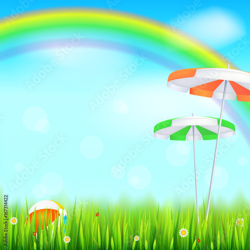 Summer background. Big bright rainbow above green field. Juicy grass  daisy flowers  ladybugs in grass on backdrop from blue sky with clouds. Landscape with Solar umbrella and inflatable ball.