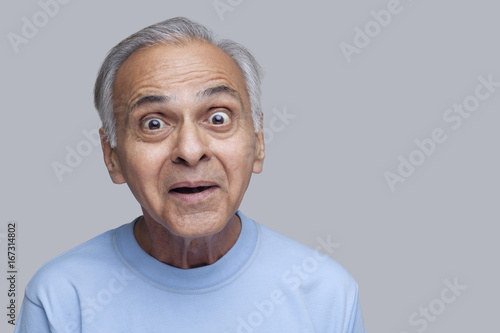 Portrait of surprised senior man raising eyebrows 