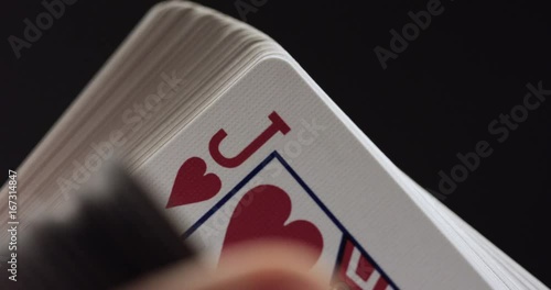 Person flicks through deck of cards, close up