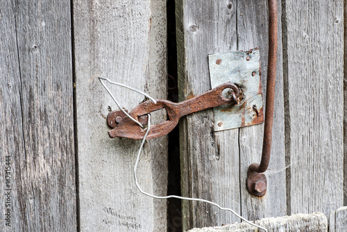 Part of an old wooden shed with rusted metal handle and latch