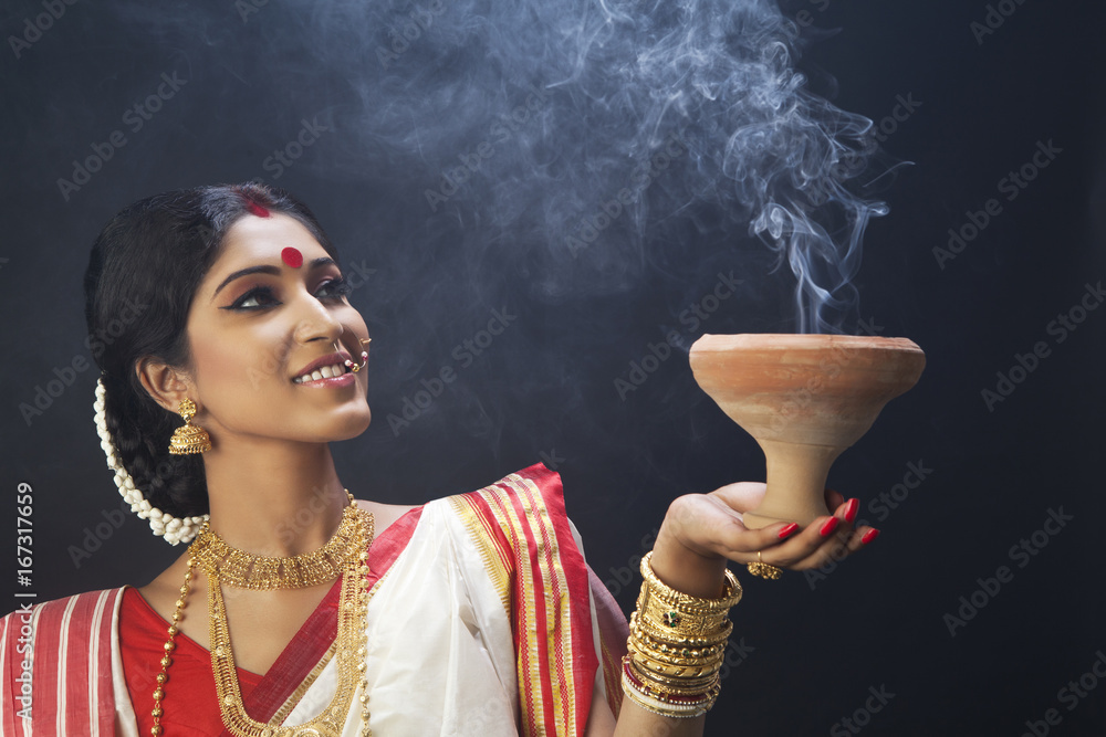 Bengali woman holding a dhunuchi Stock Photo | Adobe Stock