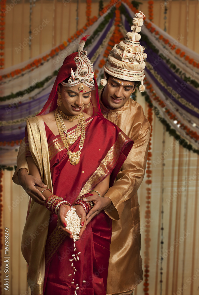 Obraz premium Bengali bride and groom making an offering 