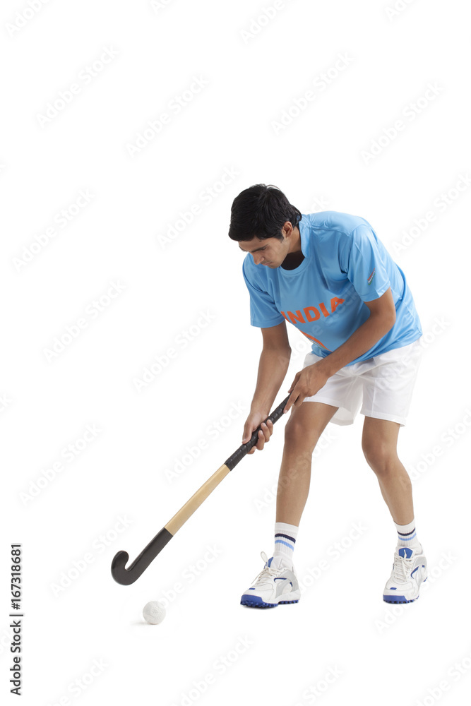 Young male Indian player practicing hockey isolated over white background Young male Indian player practicing hockey isolated over white background