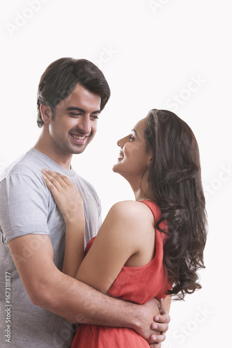 Happy young couple embracing against over background