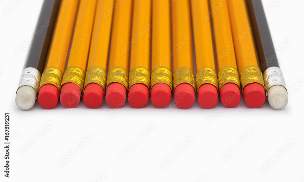 Yellow and black pencils with erasers in a row Yellow and black pencils with erasers in a row