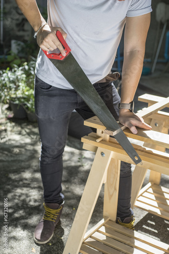 Carpenter holding a hand saw on the work bench