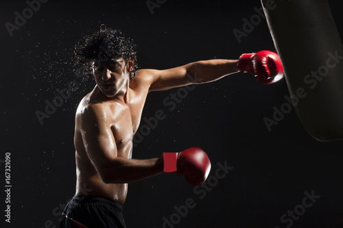 Handsome male boxer hitting heavy bag  © IndiaPix